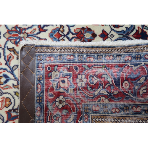 2137 - A CREAM GROUND KASHAN RUG with yellow and blue central medallion and dark blue spandrels on a floral... 