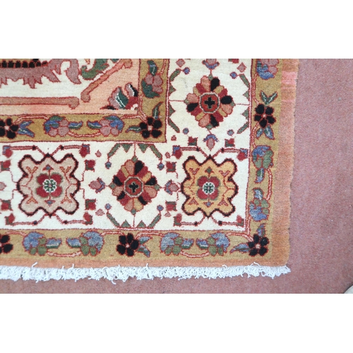 2138 - A PEACH GROUND HERIZ RUG decorated with six panelled ground with foliate and urn designs and flower ... 