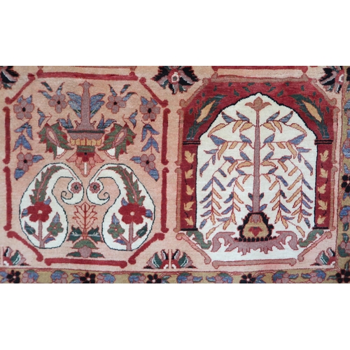 2138 - A PEACH GROUND HERIZ RUG decorated with six panelled ground with foliate and urn designs and flower ... 