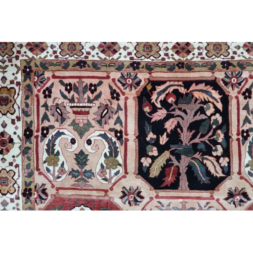 2138 - A PEACH GROUND HERIZ RUG decorated with six panelled ground with foliate and urn designs and flower ... 