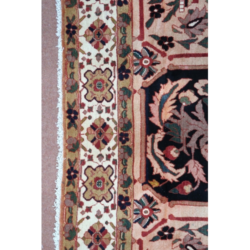 2138 - A PEACH GROUND HERIZ RUG decorated with six panelled ground with foliate and urn designs and flower ... 