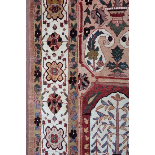 2138 - A PEACH GROUND HERIZ RUG decorated with six panelled ground with foliate and urn designs and flower ... 