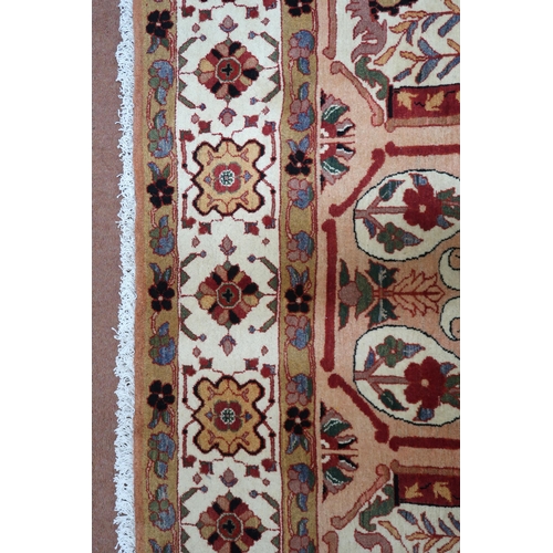 2138 - A PEACH GROUND HERIZ RUG decorated with six panelled ground with foliate and urn designs and flower ... 