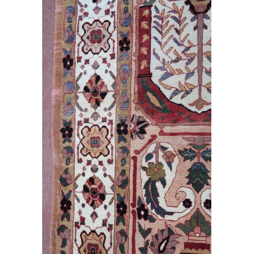 2138 - A PEACH GROUND HERIZ RUG decorated with six panelled ground with foliate and urn designs and flower ... 