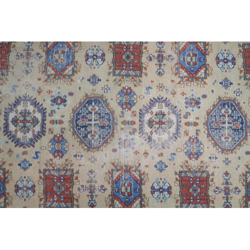 2140 - A LARGE BEIGE GROUND JAMES TEMPLETON & CO LTD STYLE RUG with all-over multicoloured lozenge desi... 