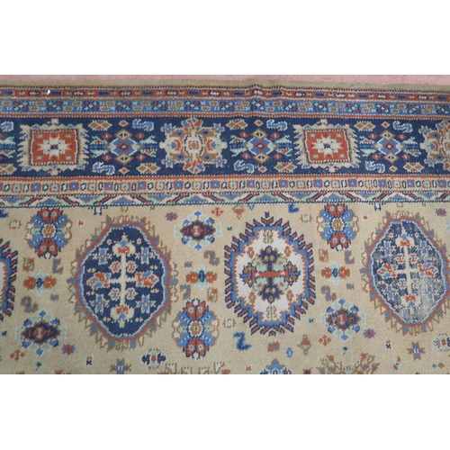 2140 - A LARGE BEIGE GROUND JAMES TEMPLETON & CO LTD STYLE RUG with all-over multicoloured lozenge desi... 