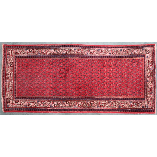 2142 - A RED GROUND ARAAK RUNNER with geometric multicoloured borders, 216cm long x 95cm wide... 