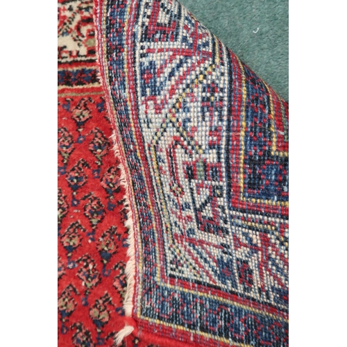 2142 - A RED GROUND ARAAK RUNNER with geometric multicoloured borders, 216cm long x 95cm wide... 