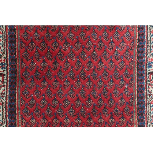 2142 - A RED GROUND ARAAK RUNNER with geometric multicoloured borders, 216cm long x 95cm wide... 