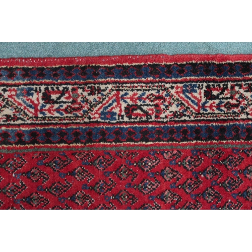 2142 - A RED GROUND ARAAK RUNNER with geometric multicoloured borders, 216cm long x 95cm wide... 