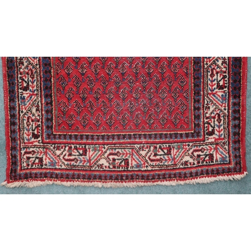 2142 - A RED GROUND ARAAK RUNNER with geometric multicoloured borders, 216cm long x 95cm wide... 