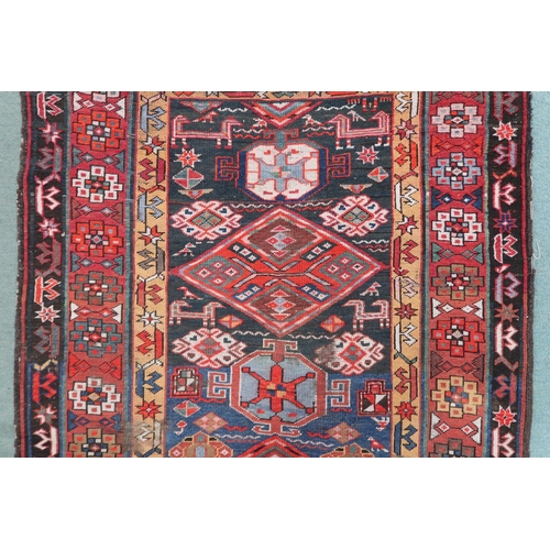 2143 - A DARK BLUE GROUND CAUCASIAN RUNNER with four multicoloured diamond medallions and multicoloure... 