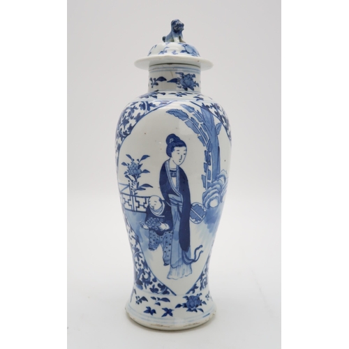 2309 - A CHINESE BLUE AND WHITE BALUSTER VASE AND COVER painted with figures in panels within scrolling fol... 