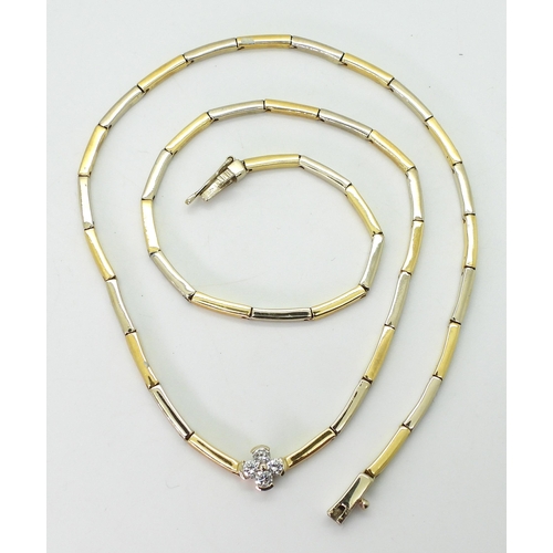 2714 - A DIAMOND FLOWER NECKLACEthe baton links of yellow and white metal have a four petaled flower in the... 
