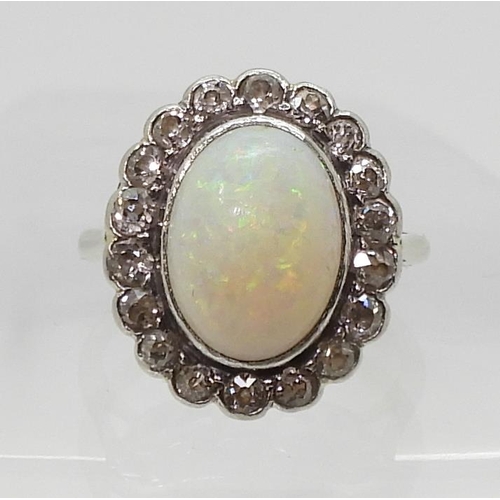 2716 - A WHITE OPAL & DIAMOND CLUSTER RINGmounted in white metal , set with a central oval cabochon opa... 