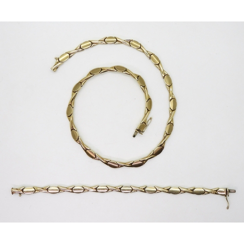 2746 - A 9CT GOLD SUITEcomprising of a necklace and matching bracelet, with brushed oval and shiny kiss sha... 