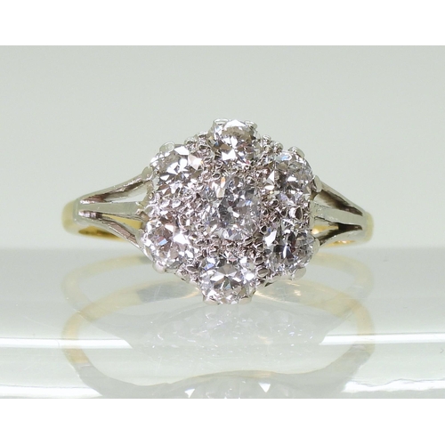 2778 - AN 18CT GOLD AND PLATINUM DIAMOND FLOWER RING with fleur de lis shoulders, set with estimated approx... 