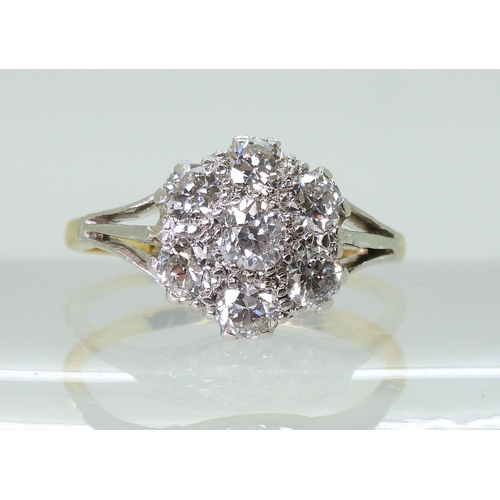 2778 - AN 18CT GOLD AND PLATINUM DIAMOND FLOWER RING with fleur de lis shoulders, set with estimated approx... 