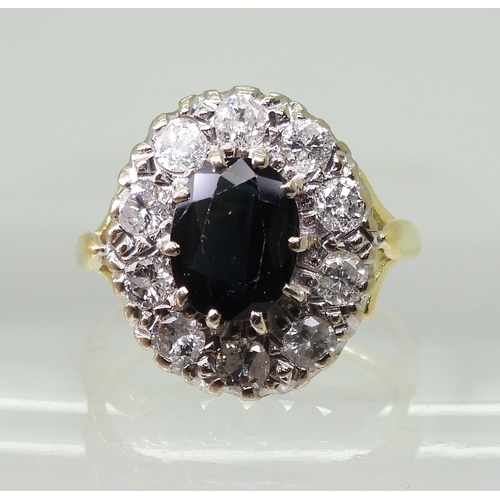 2785 - A SAPPHIRE & DIAMOND CLUSTER RINGthe 18ct gold mount with fleur de lis shoulders, is set with a ... 