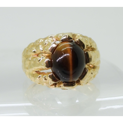 2790 - A GENTS RETRO TIGERS EYE RINGmade in bright yellow metal, the domed star burst ring is set with a  1... 