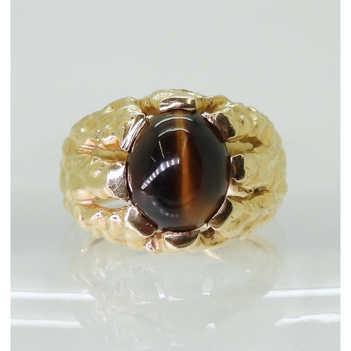 2790 - A GENTS RETRO TIGERS EYE RINGmade in bright yellow metal, the domed star burst ring is set with a  1... 