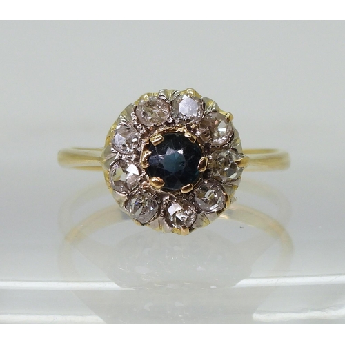 2792 - BLUE GEM & DIAMOND FLOWER RINGthe 18ct gold shank with galleried mount is set with a 4.5mm blue ... 