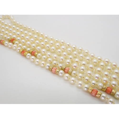 2796 - TWO STRINGS OF PEARLSa string of Mikimoto pearls with coral and 9ct gold bead details, the tongue of... 