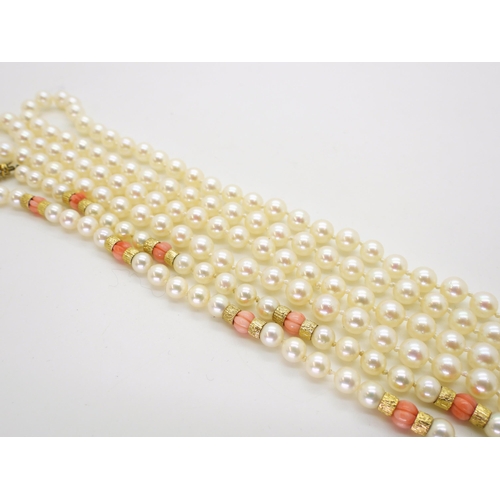 2796 - TWO STRINGS OF PEARLSa string of Mikimoto pearls with coral and 9ct gold bead details, the tongue of... 