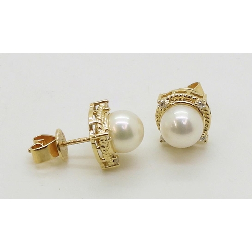 2798 - PEARL & DIAMOND EARRINGSmade in 18ct gold set with a pearl each approx 7.1mm, with the rope bord... 