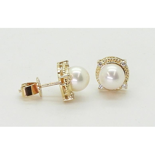 2798 - PEARL & DIAMOND EARRINGSmade in 18ct gold set with a pearl each approx 7.1mm, with the rope bord... 