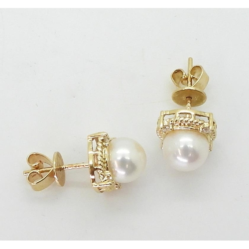 2798 - PEARL & DIAMOND EARRINGSmade in 18ct gold set with a pearl each approx 7.1mm, with the rope bord... 