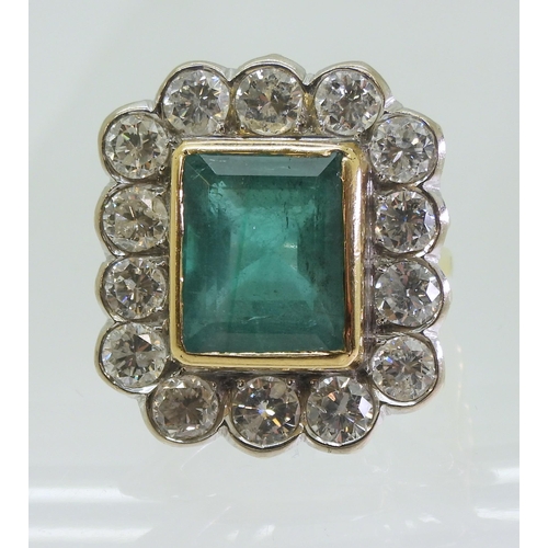 2805 - AN EMERALD & DIAMOND CLUSTER RINGthis substantial ring is set with a large step cut emerald with... 