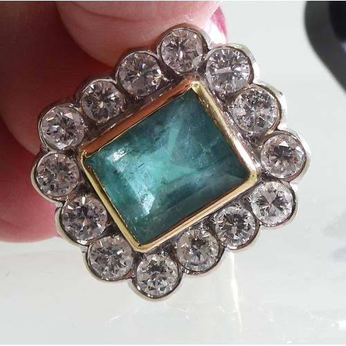 2805 - AN EMERALD & DIAMOND CLUSTER RINGthis substantial ring is set with a large step cut emerald with... 