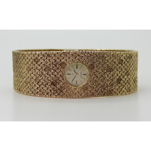 2939 - A LADIES RETRO OMEGAthe 9ct wide cuff style woven bracelet has all over texture, with a 1cm wide gol... 