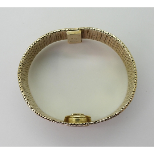 2939 - A LADIES RETRO OMEGAthe 9ct wide cuff style woven bracelet has all over texture, with a 1cm wide gol... 