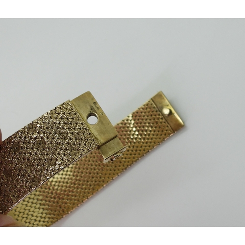 2939 - A LADIES RETRO OMEGAthe 9ct wide cuff style woven bracelet has all over texture, with a 1cm wide gol... 