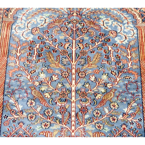 2140A - A BLUE GROUND PERSIAN TREE OF LIFE PATTERN RUG decorated with stylized animals within flower he... 