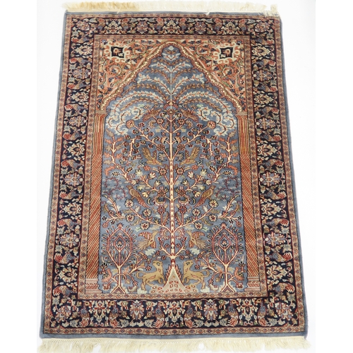 2140A - A BLUE GROUND PERSIAN TREE OF LIFE PATTERN RUG decorated with stylized animals within flower he... 