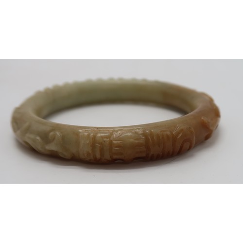 2303A - A CHINESE HARDSTONE CARVED BANGLE decorated with calligraphy,scrolls and foliage, 68 grams, 9cm... 