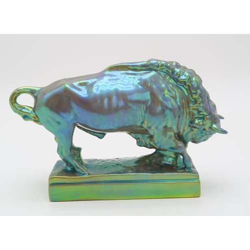 2156 - A ZSOLNAY PECS MODEL OF A BISONmodelled with head lowered, on rectangular base, with eosin iridescen... 