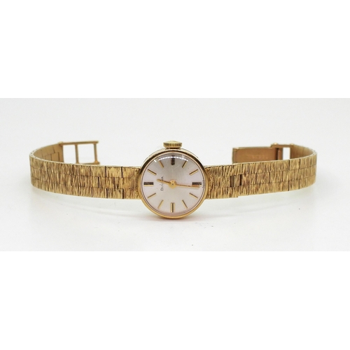 A 9ct gold ladies Bulova watch with integral strap engraved with 25 years service to possibly Ladybird Children's Clothes, engraved with a ladybird. Weight 22.2gms