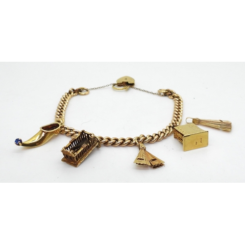 810 - A 15ct gold curb chain charm bracelet with a decorative heart shaped clasp (retailed by Georg Jensen... 