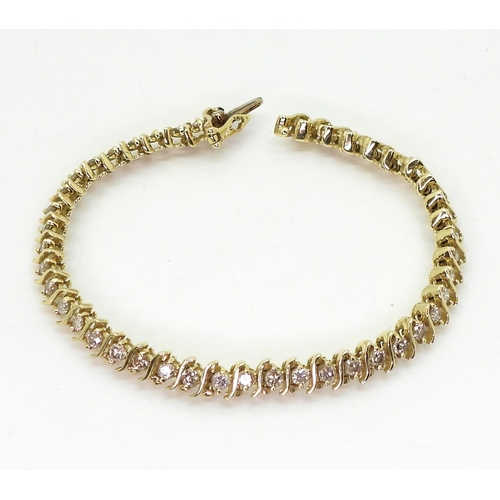 816 - A 14k gold diamond line bracelet, with 'S' shaped links and set with 2.20cts of brilliant cut diamon... 