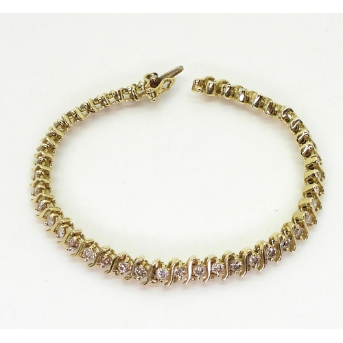 816 - A 14k gold diamond line bracelet, with 'S' shaped links and set with 2.20cts of brilliant cut diamon... 