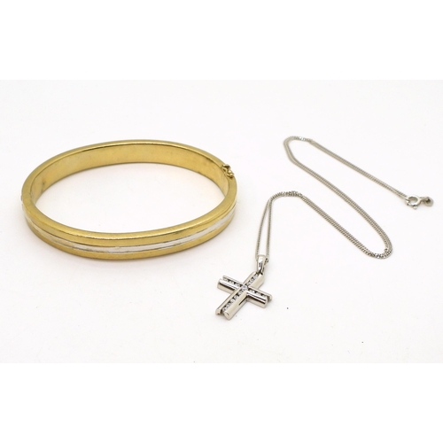 818 - A 9ct gold bi colour gold bangle, inner diameter 6.2cm x 5.1cm, and a 9ct gold cz set cross with a 9... 