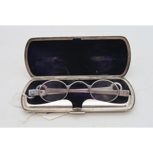 385 - A cased pair of silver spectacles, the stamped sterling case with hammered decoration and a vacant r... 