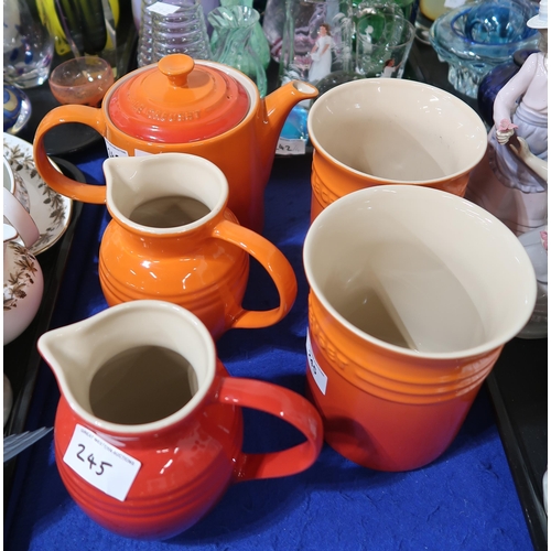 245 - A Le Creuset orange teapot, two jugs (one red) and two utensil pots