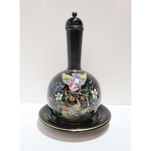 268 - A Victorian bottle vase, with stand and lid,  painted in enamels with a bird in a tree with but... 