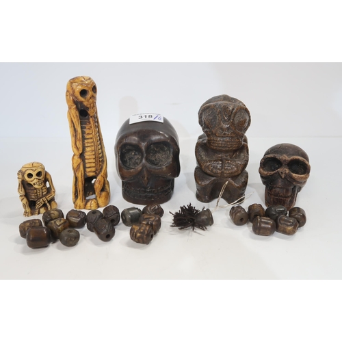 318 - A set of Eastern stone beads, carved as heads, carved bone models of skeletons, a carved wooden skul... 