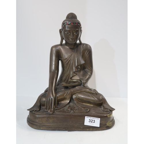 323 - A 20th century Burmese cast bronze Shakyamuni buddha, seated in lotus pose, wearing folded and pleat... 